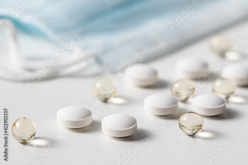 Red capsules, pills and medical masks on a white background. Health care, medical, pharmacy and illness concept