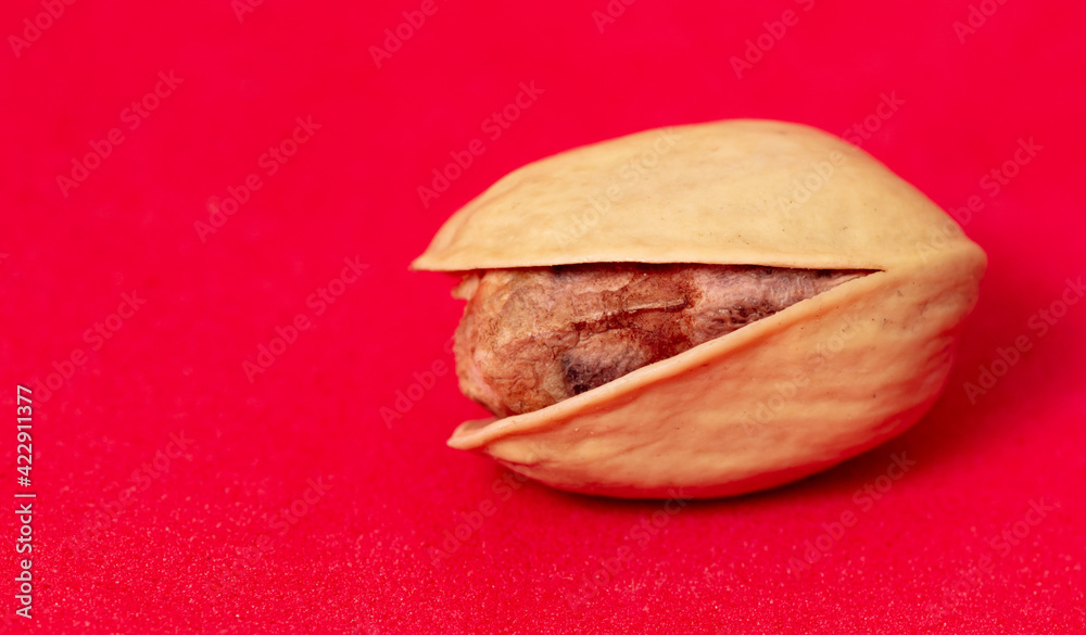 Close-up of fresh pistachio nuts on a red background. Close-up of fresh pistachio nuts on a red background.