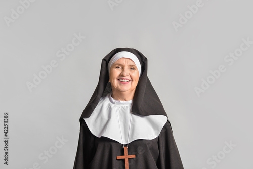 Senior nun on light background