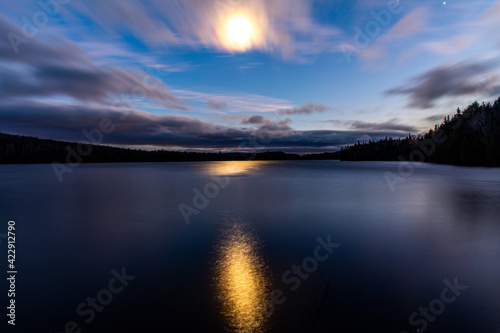 vue sur un lac la nuit avec la lumière de la lune qui danse sur le lac