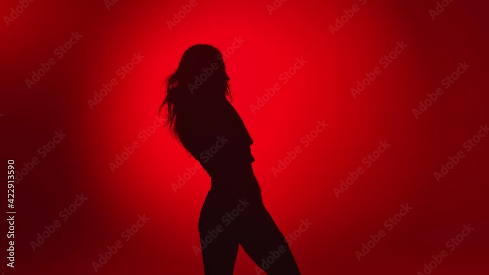 Seductive woman dancer shadow demonstrate dance movement isolated on red. Shot with RED camera in 4K