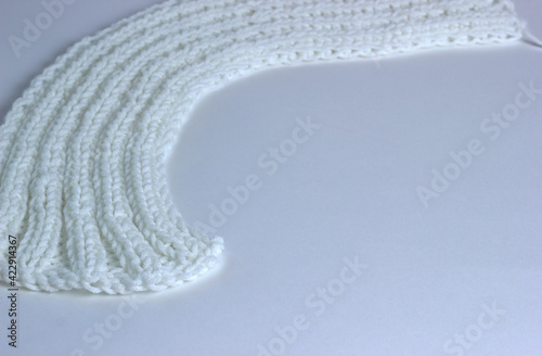 White knitted textured background with a pattern, acrylic and cotton knit fabric, closeup. Copy spase
