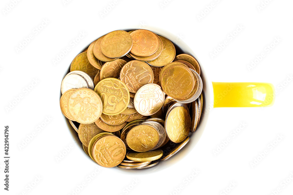 Metal coins in a ceramic cup isolated on a white background. Keeping personal savings. Financial crisis, devaluation of the ruble. Selective focus. Copy space for text. Metal coins in a ceramic cup isolated on a white background. Keeping personal savings. Financial crisis, devaluation of the ruble. Selective focus. Copy space for text.