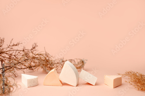 Cosmetic sponges on a beige background, modern trendy still life, monochrome, earth tones, neutral, dry herb, beauty industry concept, makeup, facial care, blogger style, banner, flyer, coupon
