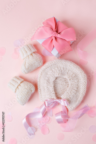 Fototapeta Naklejka Na Ścianę i Meble -  White warm handknitted baby shoes and bonnet for little girl or boy and gift box - concept of first step, birthday party, baby shower, anniversary. Little booties for newborn baby, mother day