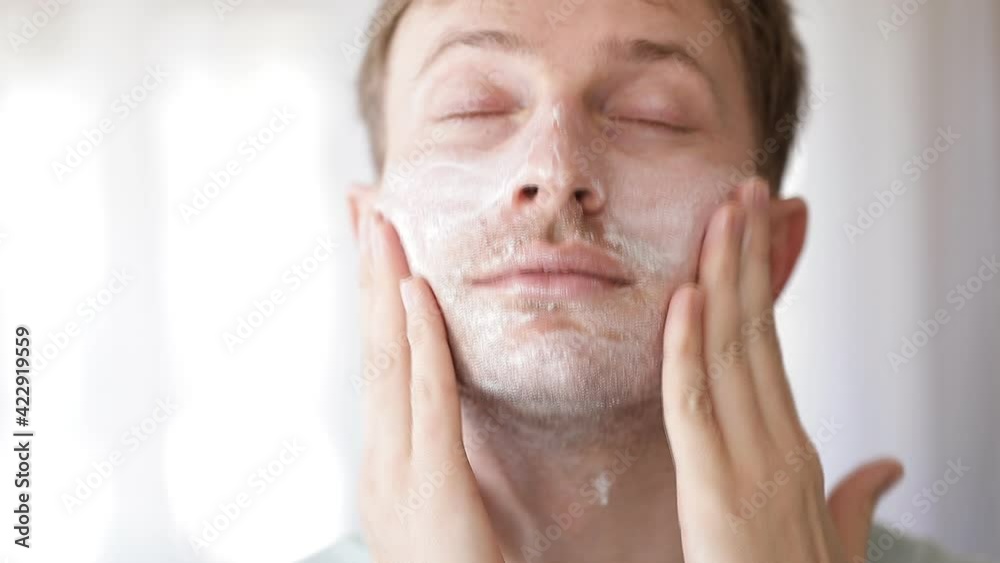Handsome man applying facial cream Handsome man applying facial cream