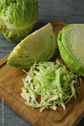 Board with fresh green cabbage on wooden background