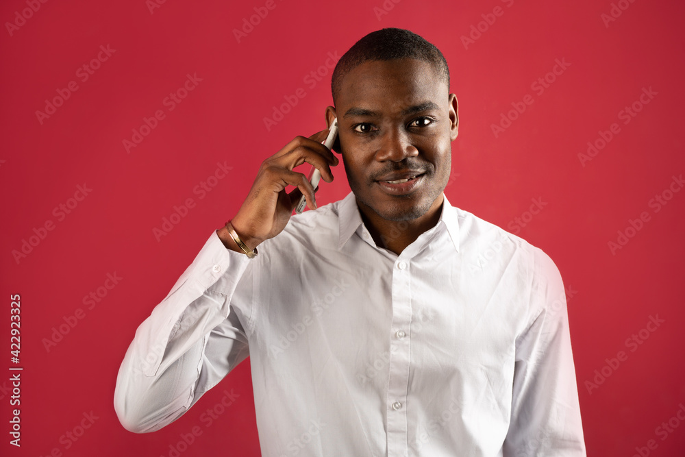 handsome young african man in white shirt with phone handsome young african man in white shirt with phone