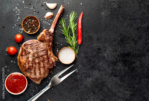 tomahawk beef steak grilled with spices on stone background with copy space for your text