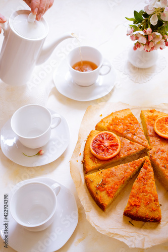 Tea with fresh warm pie with oranges on a beautifully decorated table