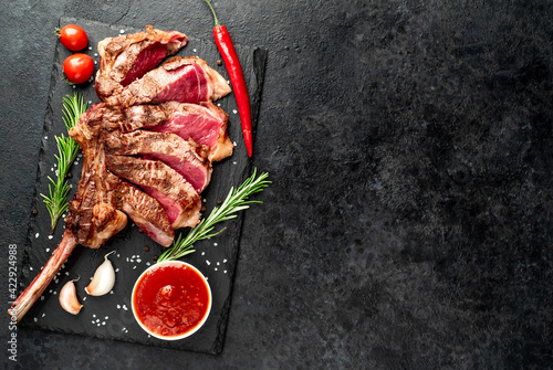 tomahawk beef steak grilled with spices on stone background with copy space for your text