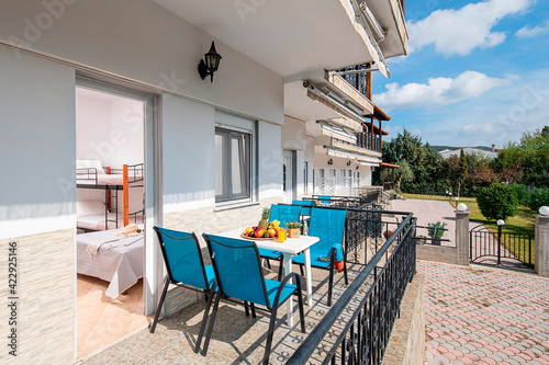 Summer garden view of modern studio room apartment with outside open terrace on white pavement floor in villa house backyard of Europe country resort hotel
