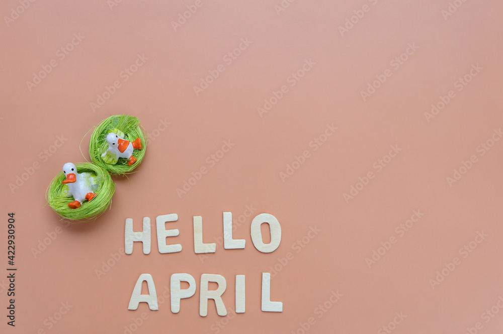 Two ceramic duck toy with Hello April wooden text. Empty space for text.