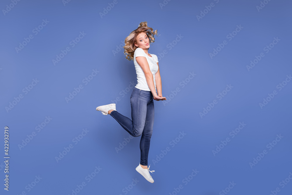 Full body profile side photo of young girl happy positive smile have fun jump up isolated over blue color background Full body profile side photo of young girl happy positive smile have fun jump up isolated over blue color background