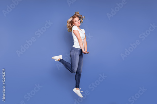 Full body profile side photo of young girl happy positive smile have fun jump up isolated over blue color background