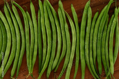 Fresh green beans on wooden background.