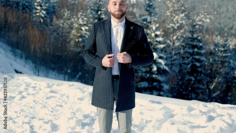 groom on the background of snow-capped mountains groom on the background of snow-capped mountains