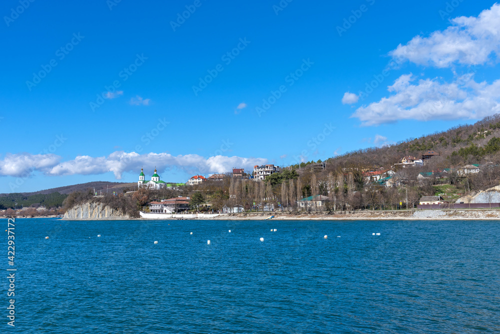 Panoramic view of Lake Abrau Dyurso in Krasnodar Krai, Russia. Picturesque view of blue lake with church on sunny spring day in Abrau Durso.