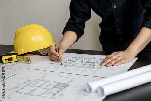 The architect and engineer are drawing up the drawings of the house according to the project received. He works in his office, he does the design according to the needs of the clients.