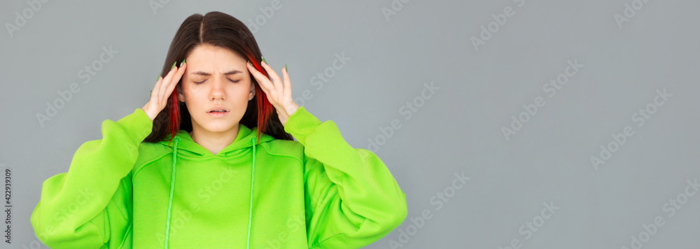 Young woman has headache isolated on gray background Young woman has headache isolated on gray background