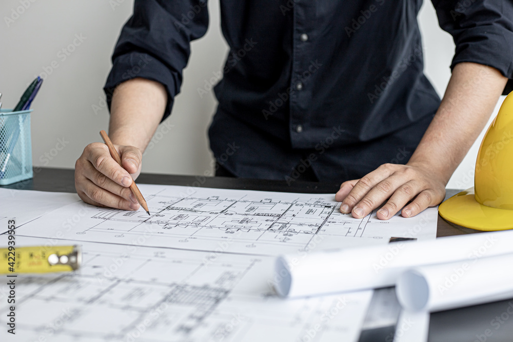 The architect and engineer are drawing up the drawings of the house according to the project received. He works in his office, he does the design according to the needs of the clients. The architect and engineer are drawing up the drawings of the house according to the project received. He works in his office, he does the design according to the needs of the clients.