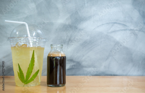 Refreshing ice hemp coffee or tea cocktail with tonic. Hard sun light, hemp leaf