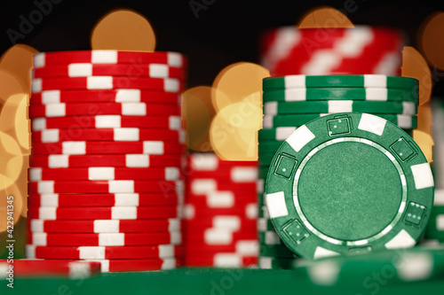 Stack of casino chips on green table against bokeh background