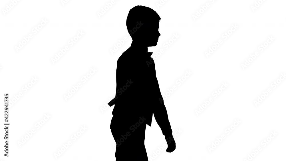 Silhouette Little boy in a waistcoat and a bow tie walking looking straight ahead. Silhouette Little boy in a waistcoat and a bow tie walking looking straight ahead.