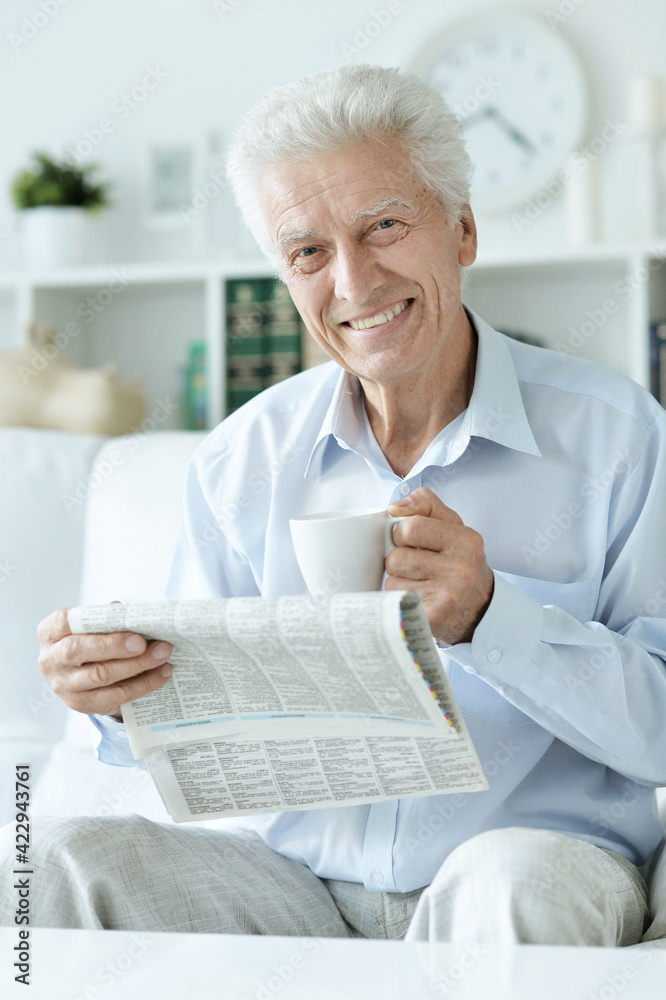 Senior man reading newspaper at home Senior man reading newspaper at home
