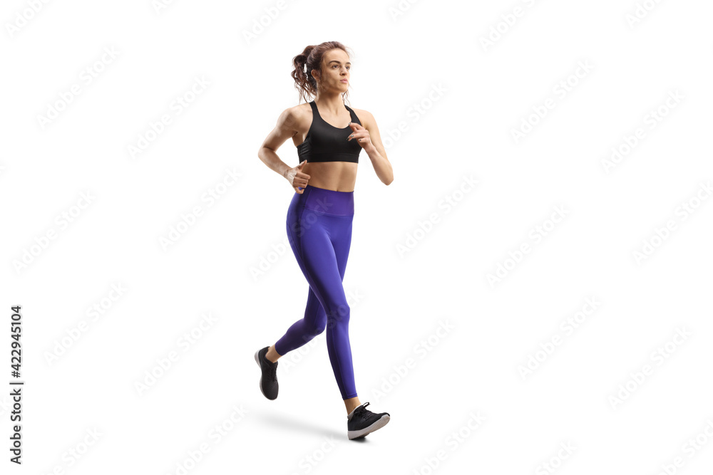 Young woman in leggings and sports top jogging