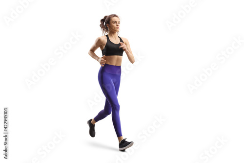 Young woman in leggings and sports top jogging