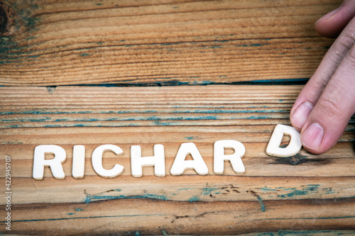 RICHARD. Name of men and boys. Birthday concept. White letters of the alphabet on a wooden background