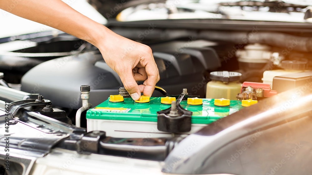 Automobile mechanic repairman checking a car engine with inspecting writing to the clipboard the checklist for repair machine, car service and maintenance. Automobile mechanic repairman checking a car engine with inspecting writing to the clipboard the checklist for repair machine, car service and maintenance.
