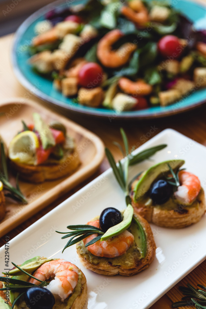 Appetizer canape with shrimp and cucumber on plate on table close up