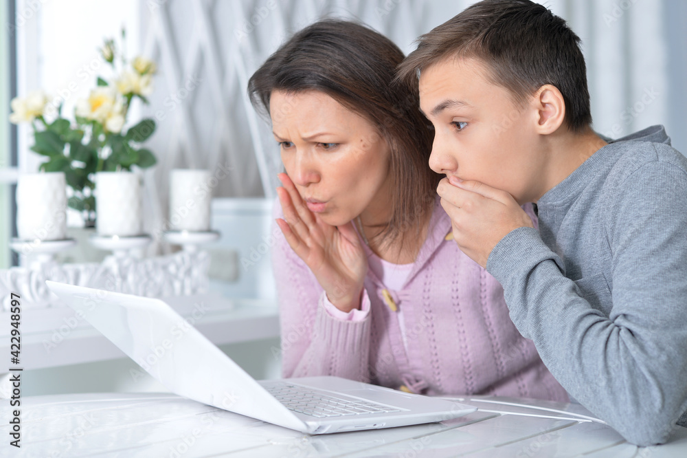 Emotional mother and son using modern laptop Emotional mother and son using modern laptop