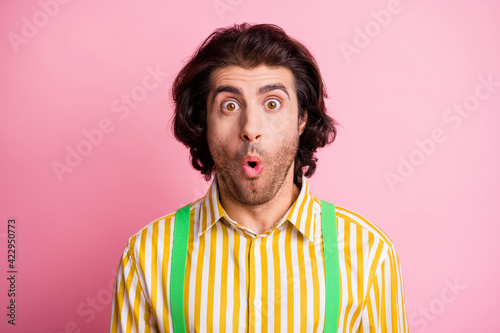 Portrait of young handsome shocked amazed surprised man look camera wear striped shirt isolated on pink color background © deagreez