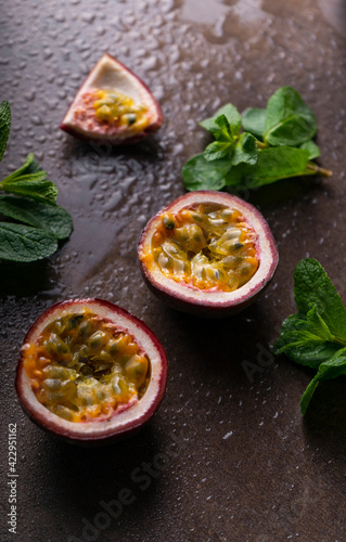 tropical fruit passion fruit on a dark background with water droplets and mint leaves. copyspace