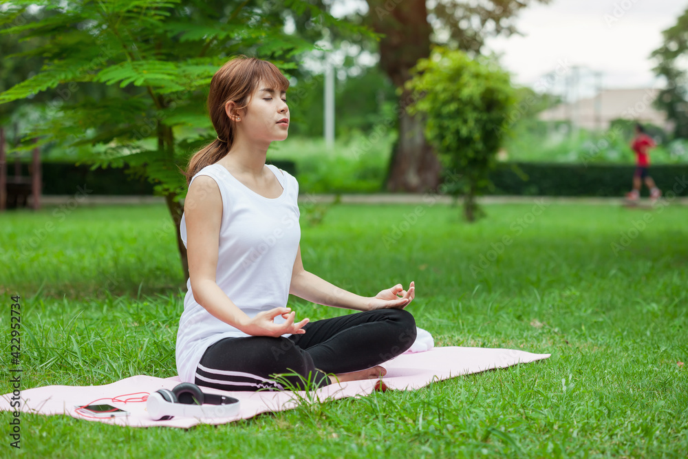 Image of Asian woman sitting and meditation yoga lotus pose outdoor park. Image of Asian woman sitting and meditation yoga lotus pose outdoor park.