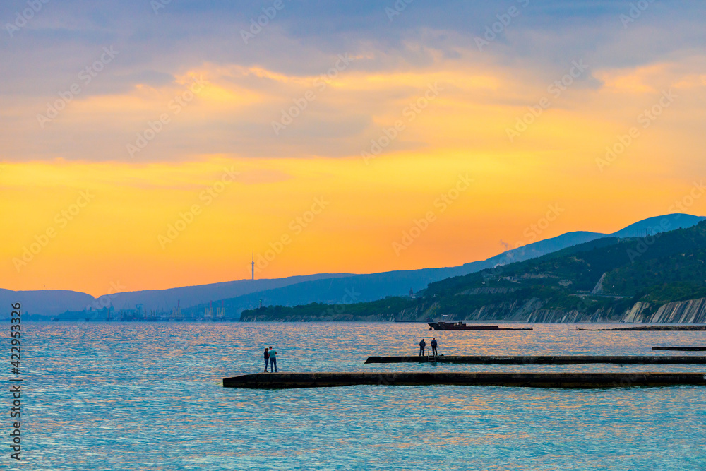 Long concrete seawall or wave breaker for protect seashore on sunset Long concrete seawall or wave breaker for protect seashore on sunset