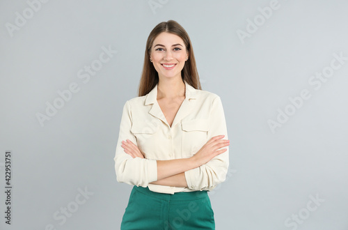 Portrait of beautiful young businesswoman on light grey background