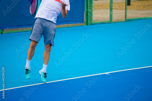 Tennis players playing tennis on a hard court on a bright sunny day © Павел Мещеряков