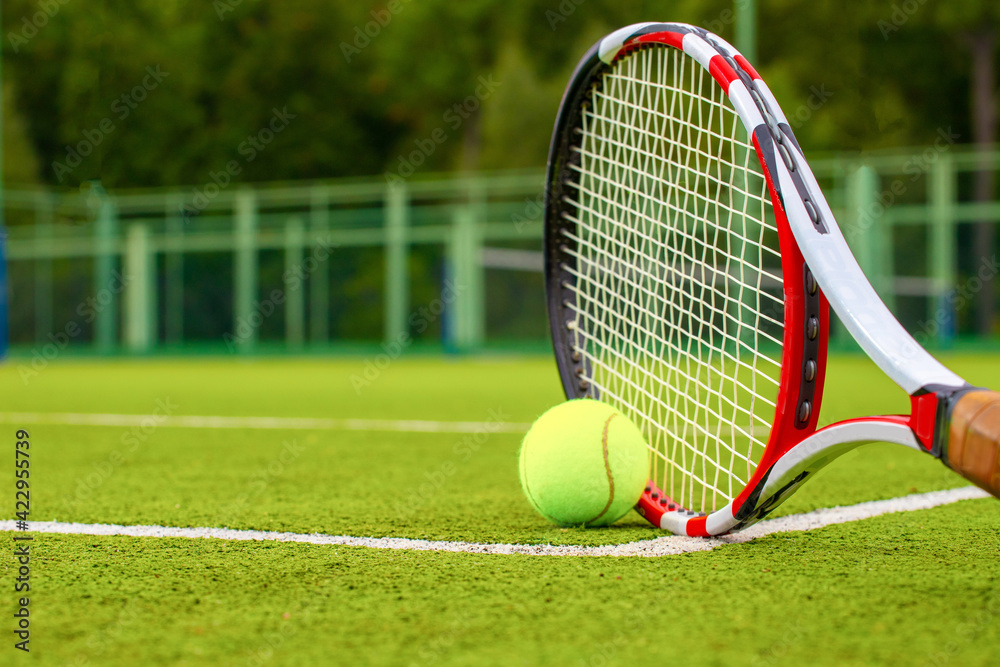 Tennis racket and tennis ball on grass court