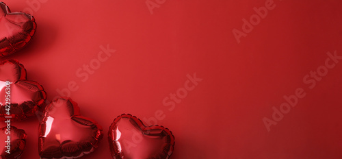 Heart shaped balloons on red background, flat lay with space for text. Saint Valentine's day celebration photo