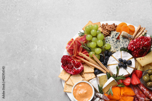 Assorted appetizers served on light grey table, top view. Space for text