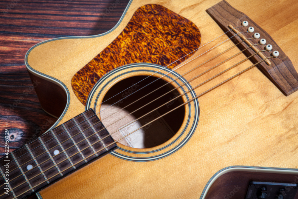 Obraz premium Close up of acoustic guitar. Acoustic guitar against an old wooden background