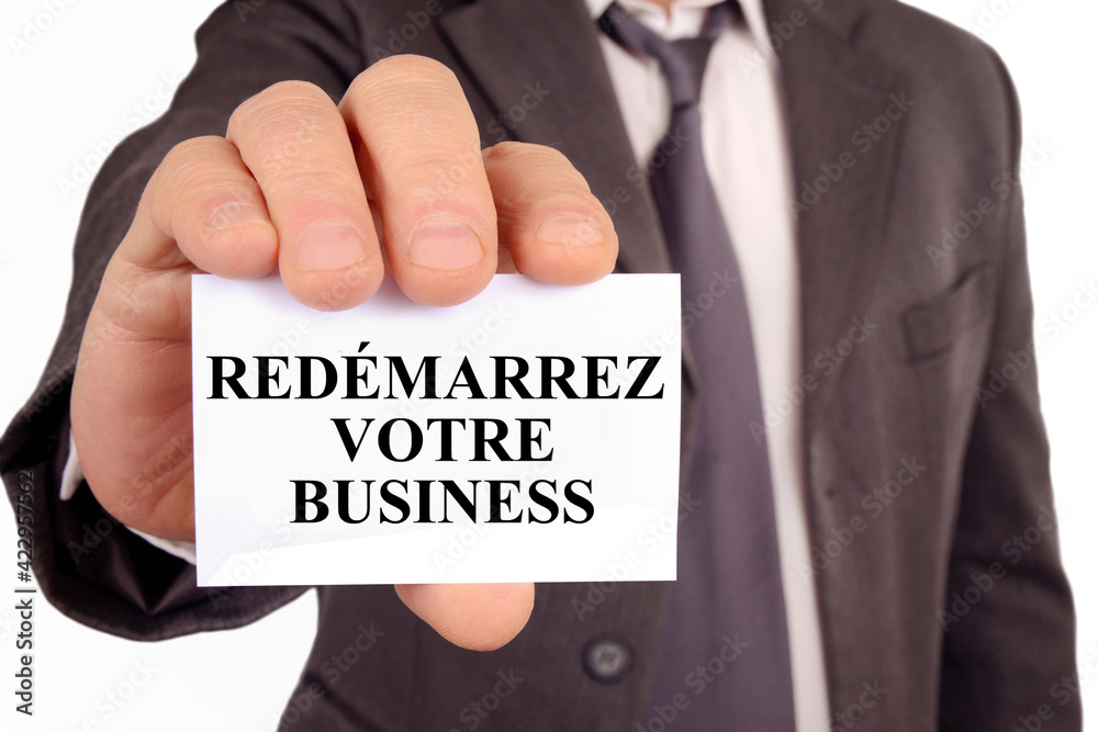 Homme d'affaires tenant une carte sur laquelle est écrit redémarrez votre affaire Homme d'affaires tenant une carte sur laquelle est écrit redémarrez votre affaire