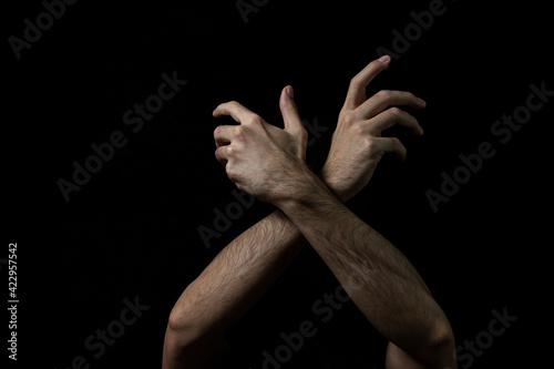 Male hands on a black background. Two male hands on a dark background. Body parts.