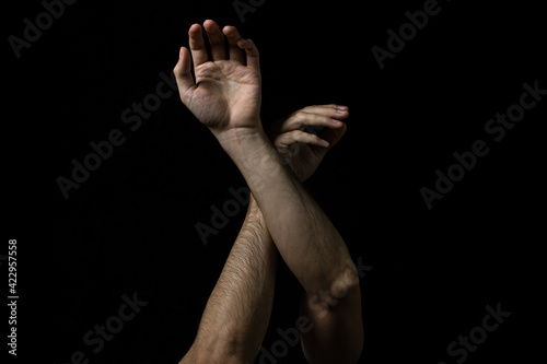 Male hands on a black background. Two male hands on a dark background. Body parts.