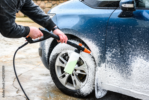 High pressure automobile cleaning with foam in car wash.