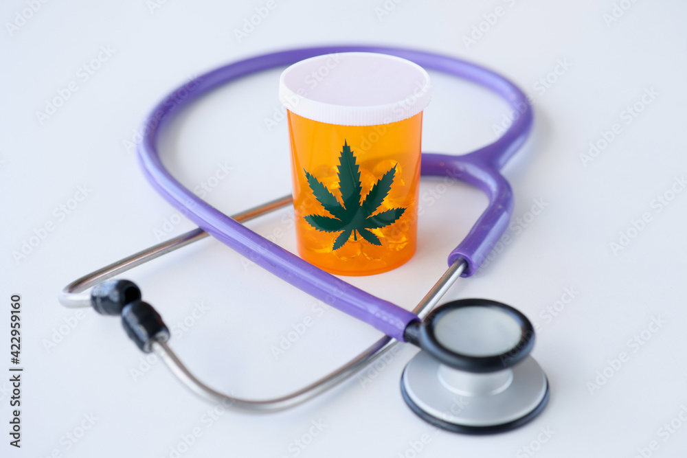 Jar of marijuana pills standing near stethoscope closeup Jar of marijuana pills standing near stethoscope closeup